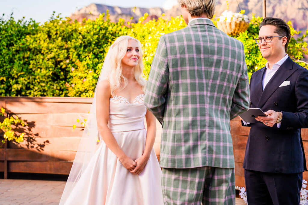 close up of bride looking at groom smiling during ceremony with red rock background at Agave of Sedona