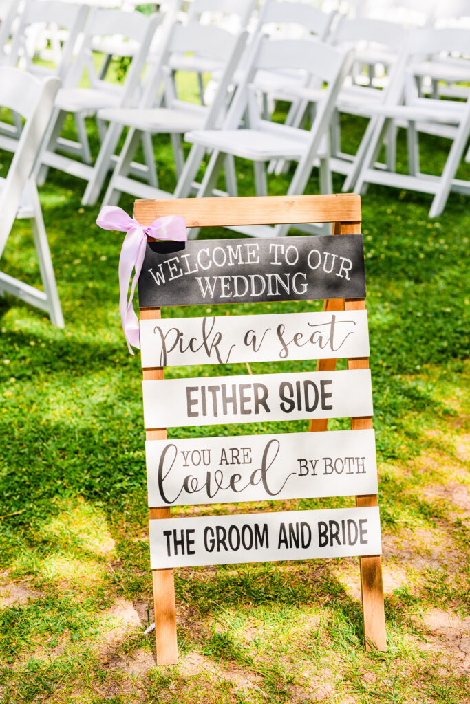 wedding decor sign and setup at the Windmill House on lawn next to trees and lake in Northern Arizona Chino Valley
