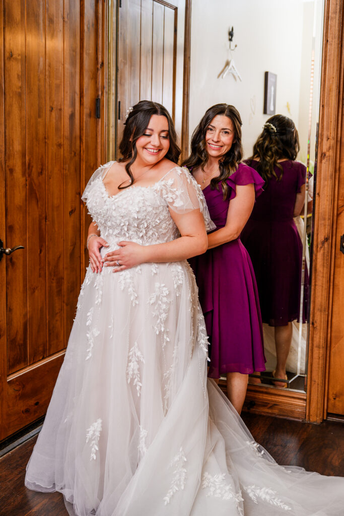 bride putting on wedding dress with mother in bridal suite at the Windmill House in Chino Valley Arizona