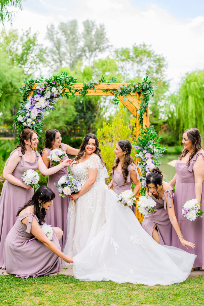 bridesmaids fix brides dress candid photo with tree background at the Windmill House Prescott Chino Valley Arizona